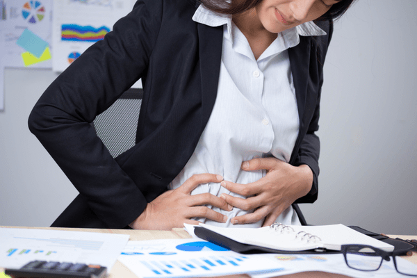 office woman having side pains in need of gastroenterologist
